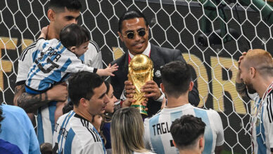 Nusret Gokce memegang trofi Piala Dunia bersama pemain Argentina
